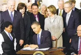  ?? AP FILE ?? With Vice President Joe Biden and others watching, President Barack Obama signs the Affordable Care Act on March 23, 2010, at the White House.