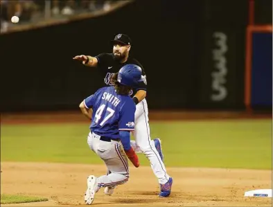  ?? Jim McIsaac / Getty Images ?? The Mets’ Luis Guillorme completes an eighth-inning double play after forcing out Josh Smith of the Rangers at Citi Field on Friday.