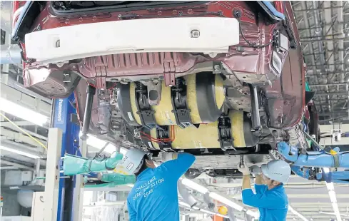  ?? AP ?? Workers place hydrogen-stored tanks, in yellow, into a Mirai fuel cell vehicle at Toyota Motor Corp’s Motomachi plant in Toyota City.