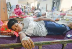  ?? — AFP ?? A young Bangladesh­i patient suffering from dengue fever rests in a bed at the Mugda Medical College and Hospital in Dhaka.