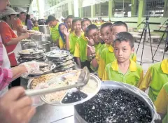  ??  ?? Students at Ban Bangkapi secondary school in Bangkok queue up for lunch.