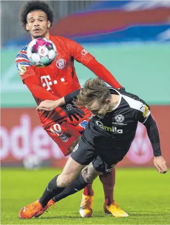  ?? FOTO: CHRISTIAN CHARISIUS/DPA ?? Enges Duell: Jannik Dehm (vorne) im Zweikampf mit Münchens Leroy Sané.
Holstein Kiel – Bayern München 6:5