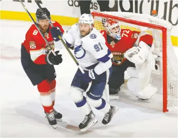  ?? JOEL AUERBACH/GETTY IMAGES ?? The Lightning's Steven Stamkos, centre, battles with Ben Chiarot in front of Panthers' goalie Sergei Bobrovsky in the second game of their series.