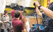  ?? COURTESY OF STEPHANIE SUNWOO ?? Incredible Café owner Liz Song (left) interacts with chef Jose Sanchez during filming of a “Restaurant: Impossible” episode on Monday.