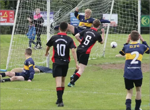  ??  ?? Darragh Malone of Bridge Rovers slides the ball to the net as Tom Keavney (10) looks on.