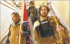  ?? Manuel Balce Ceneta Associated Press ?? A MAN identified as Kevin Seefried, left, has been charged in the Jan. 6 storming of the U.S. Capitol after a co-worker of his son helped the FBI identify him.