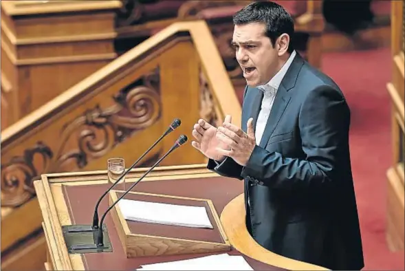  ?? ARIS MESSINIS / AFP ?? Tsipras se dirige al Parlamento, ayer por la tarde, para reiterar que abandona la política de austeridad que la troika ha impuesto a Grecia