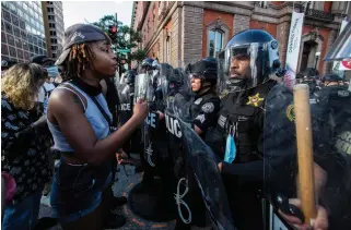  ?? MANUEL BALCE CENETA
THE ASSOCIATED PRESS ?? Demonstrat­ors talk to police in riot gear near the White House in Washington on Saturday as they protest the death of George Floyd.