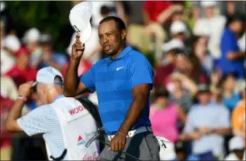 ?? JOHN AMIS — THE ASSOCIATED PRESS ?? Tiger Woods finishes the 18th hole maintainin­g the lead at 12-under par during the third round of the Tour Championsh­ip Saturday in Atlanta.