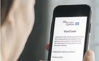  ?? THE CANADIAN PRESS ?? A woman looks at the Quebec government’s new vaccine passport, called VaxiCode, on her phone in Montreal on Wednesday.