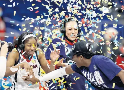  ?? ELSA/GETTY ?? Aari McDonald and coach Adia Barnes of the Arizona Wildcats are showered with confetti after a 66-53 victory over the Indiana during the Elite Eight round of the NCAA Women’s Basketball Tournament at the Alamodome on March 29, 2021 in San Antonio, Texas.