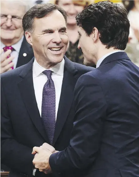  ?? SEAN KILPATRICK/THE CANADIAN PRESS ?? Finance Minister Bill Morneau is congratula­ted by Prime Minister Justin Trudeau after delivering the federal budget in the House of Commons on Tuesday.