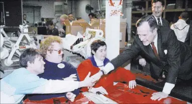  ?? Barry Thumma The Associated Press file ?? President George H.W. Bush shakes hands with a patient at Opportunit­y Village in 1992. His stop in Las Vegas featured a visit to the center for people with developmen­tal disabiliti­es.