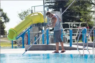  ?? Herald photo by Greg Bobinec ?? Lifeguard Mike Poirier listens to some tunes as he cleans out Henderson Pool before it is open to the public on a hot Friday morning.