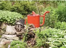  ??  ?? A red watering can and birdhouse add character (above); a stone pathway through the yard connects the patio (right) to the stairs.