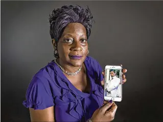  ?? LANNIS WATERS / THE PALM BEACH POST ?? Sharee Brooks with a photo of her son, Connis Robinson, on Aug. 22. Robinson was killed in 2015 outside a Riviera Beach convenienc­e store.