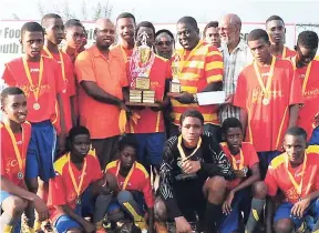  ?? PHOTO BY PAUL CLARKE ?? Head coach of the newly crowned Trelawny FA Progressiv­e Group Under-17 champions Village United, Dean Ellis (centre right), accepts the winning trophy from businessma­n Ryan Keating (centre, left) following Sunday’s 2-1 win in the final over Clarks Town...