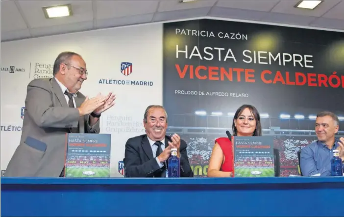  ??  ?? OVACIÓN A LA AUTORA. Alfredo Relaño se pone en pie para aplaudir, junto a Adelardo y Pantic, a Patricia Cazón, escritora de ‘Hasta siempre, Vicente Calderón’, en la sala de Prensa del estadio.