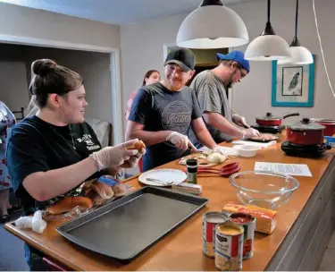  ?? Associated Press ?? n Caetlin Rains, left, Leighton Patrick, Bruce Bennett and others participat­e in a cooking class Jan. 26 at Northwood Baptist Church in Longview, Texas.