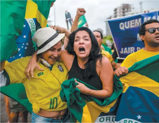  ?? PHOTO AFP ?? Des partisans de Jair Bolsonaro sont descendus dans la rue pour célébrer devant la demeure du candidat à Rio de Janeiro.