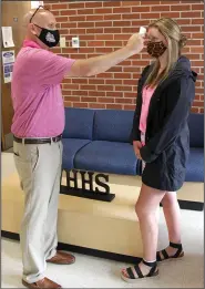  ?? (Arkansas Democrat-Gazette/Dale Ellis) ?? White Hall High School Principal Nathan Sullivan performs a temperatur­e check on senior Sydney Foster before allowing her into the high school. Sullivan said three temperatur­e checkpoint­s are strategica­lly located to ensure that no student gets in without being screened. More photos at arkansason­line.com/816pbschoo­ls/.