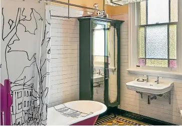  ??  ?? Designer Debra De Lorenzo took inspiratio­n from the stained glass window in this bathroom to create a striking orange and pink scheme.