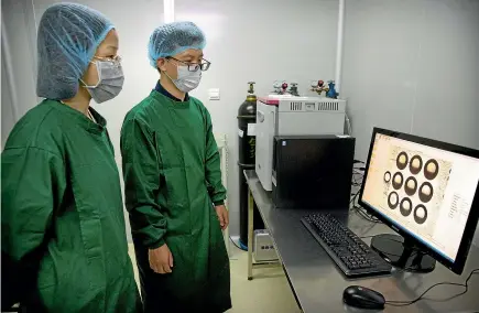  ?? AP ?? Zhou Xiaoqin, left, and Qin Jinzhou, who were part of the team working with scientist He Jiankui, view a time lapse image of embryos on a computer screen at a laboratory in Shenzhen in southern China’s Guandong province.