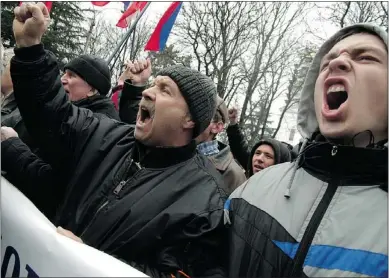  ?? — GETTY IMAGES ?? Pro-Russian demonstrat­ors shout slogans in front of the Crimean parliament building in Simferopol on Thursday. Pro-Kremlin gunmen seized government buildings.