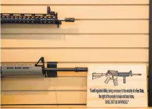  ?? Jim Watson / AFP / Getty Images ?? A placard about U.S. gun rights hangs on the wall next to assault rifles for sale at a gun store in Chantilly, Va.