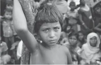  ?? K M ASAD / AFP / GETTY IMAGES ?? A Rohingya girl with newly arrived refugees who fled to Bangladesh from Myanmar on Wednesday. More than 125,000 refugees have flooded across the border into Bangladesh. Most are Rohingya, a Muslim ethnic minority the government of Buddhist-majority...