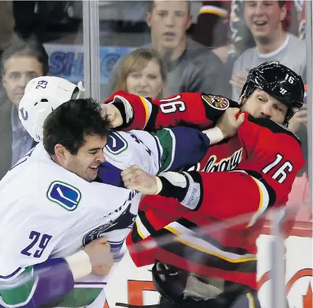  ?? Christina Ryan/calgary Herald/files ?? Flames’ Brian McGrattan, shown battling Vancouver’s Tom Sestito, billed learning how to fight as “a defensive safeguard for young guys.”