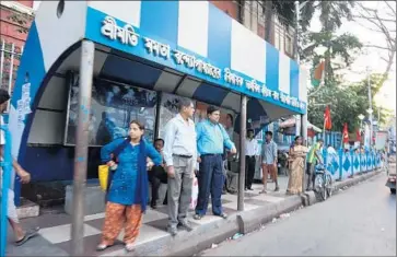  ?? Photograph­s by Shashank Bengali
Los Angeles Times ?? KOLKATA BUS STOPS, government buildings, police stations, curbsides, overpasses, food stalls, bridges, tree trunks, traffic cones and even trash compactors have all been painted blue and white.