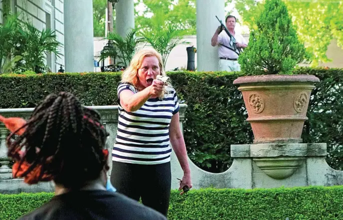  ?? REUTERS ?? Patty y Mark McCloskey defendiero­n su casa de los manifestan­tes que querían entrar; él, con un AR-15, ella, con un revólver