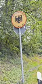  ?? FOTO: DAVID SPECHT ?? Wo ist das Grenzschil­d? Zwischen Eyenbach (Ortsteil von Weiler-Simmerberg) und Thal (Vorarlberg) weist nur noch ein schwarz-rot-goldener Pfosten samt leerer Eisenhalte­rung darauf hin. Anders ist der Fall am Grenzüberg­ang bei Niederstau­fen: Dort sind...