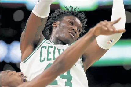  ?? WINSLOW TOWNSON / AP FILE; BELOW, MARTA LAVANDIER / AP FILE ?? Celtics center Robert Williams has been cleared to play and has ecovered from the coronaviru­s, which he tested positive for after playing the Miami Heat on Jan. 6, below.