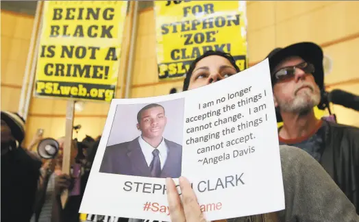  ?? Rich Pedroncell­i / Associated Press ?? Anita Ross holds a photo of shooting victim Stephon Clark during a March 22 protest at Sacramento City Hall.