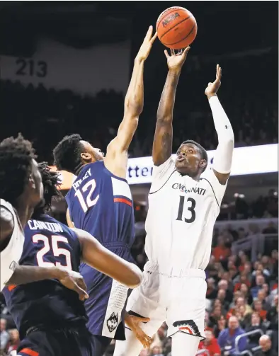  ?? John Minchillo / Associated Press ?? Cincinnati’s Tre Scott shoots over UConn’s Tyler Polley during Saturday’s game in Cincinnati.