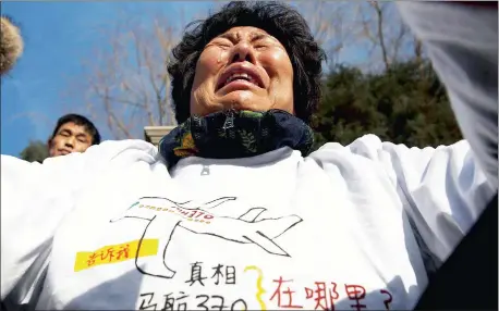  ?? Picture: AP ?? ANGUISH: Liu Guiqiu, whose son was on board Malaysia Airlines Flight 370, cries as she protests near the Malaysian embassy in Beijing on the one-year anniversar­y of the plane’s disappeara­nce yesterday. Words on the T-shirt read “Truth Malaysia Airlines 370 where is it?”.