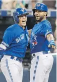  ?? FRED THORNHILL/THE CANADIAN PRESS ?? Toronto’s Ryan Goins, left, celebrates his grand slam against the New York Yankees with Richard Urena Friday at Rogers Centre.