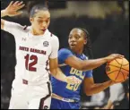  ?? Associated Press ?? UCLA guard Charisma Osborne (20) looks to pass around South Carolina guard Brea Beal (12) during the first half on Tuesday in Columbia, S.C. South Carolina defeated UCLA 73-64.