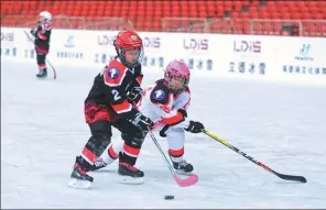  ?? CHENG GONG / FOR CHINA DAILY ?? Children play ice hockey at the Bird’s Nest, or the National Stadium, in Beijing on Dec 23.