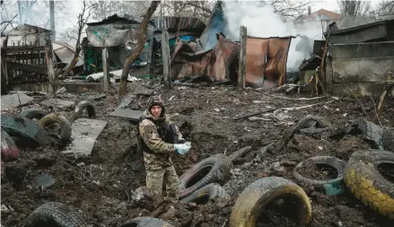  ?? YASUYOSHI CHIBA/GETTY-AFP ?? A police officer inspects damage from a rocket strike Thursday in Kramatorsk, Ukraine.