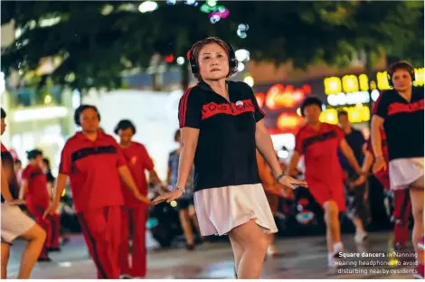  ??  ?? Square dancers in Nanning wearing headphones to avoid disturbing nearby residents