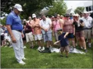  ?? MARK MIRKO/HARTFORD COURANT VIA AP ?? UConn women’s basketball coach Geno Auriemma, left, watches Jake Ragan, 5, try to swing Auriemma’s driver before he teed-off on the first hole at the Travelers Championsh­ip Celebrity Pro-Am at TPC River Highlands last Wednesday.