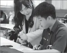  ?? YANG WANLI / CHINA DAILY ?? Pornpawee Sangchalin (left) assists a student during a Mandarin class at a school in Bangkok.