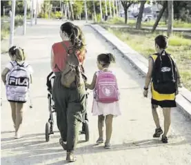  ?? JOAN CORTADELLA­S ?? Miembros de una familia numerosa, de paseo por un parque.