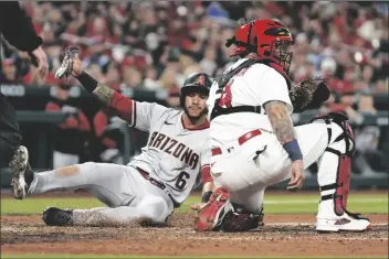  ?? JEFF ROBERSON/AP ?? ARIZONA DIAMONDBAC­KS’ DAVID PERALTA (6) scores past St. Louis Cardinals catcher Yadier Molina during the sixth inning of a game on Friday in St. Louis.