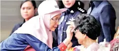  ?? - Bernama photo ?? Deputy Prime Minister Datuk Seri DrWanAziza­hWan Ismail (left) dabbing the perspirati­on off Prime Minister’s wife Tun Dr Siti Hasmah’s brow during the 61st National Day celebratio­n in Putrajaya yesterday.