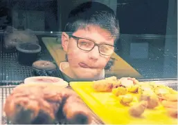  ??  ?? Angus Muirhead, 9, licks his lips at the sight of the deep-fried festive fare.