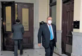  ?? SAM DORAN/SHNS ?? House Majority Leader Ron Mariano, who has been rounding up votes to become the next speaker, walked back to his office behind the private members' lounge Wednesday toting a Christmas gift bag, after the House adjourned its last session before the holiday.